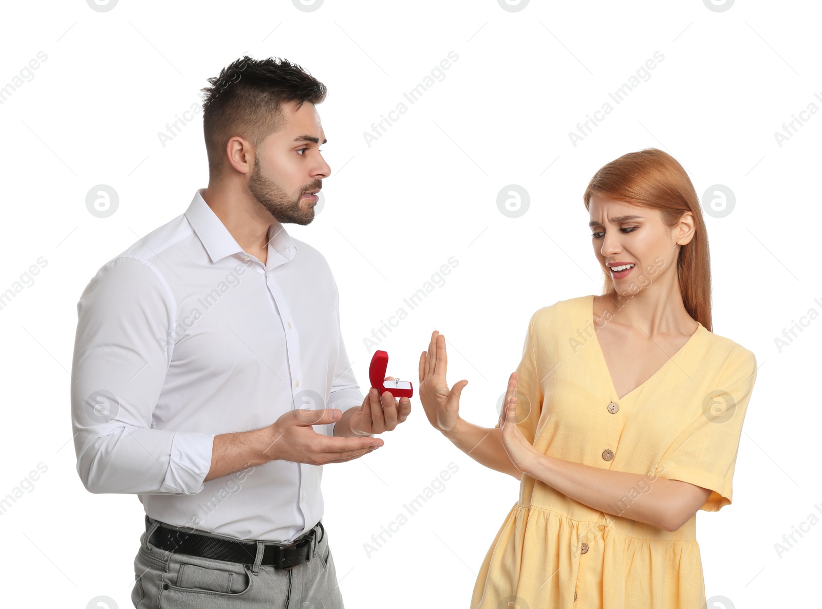 Photo of Young woman rejecting engagement ring from boyfriend on white background