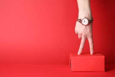 Photo of Woman wearing elegant wristwatch on red background, closeup. Space for text