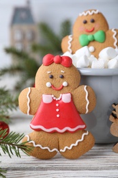 Decorated gingerbread cookies on white wooden table