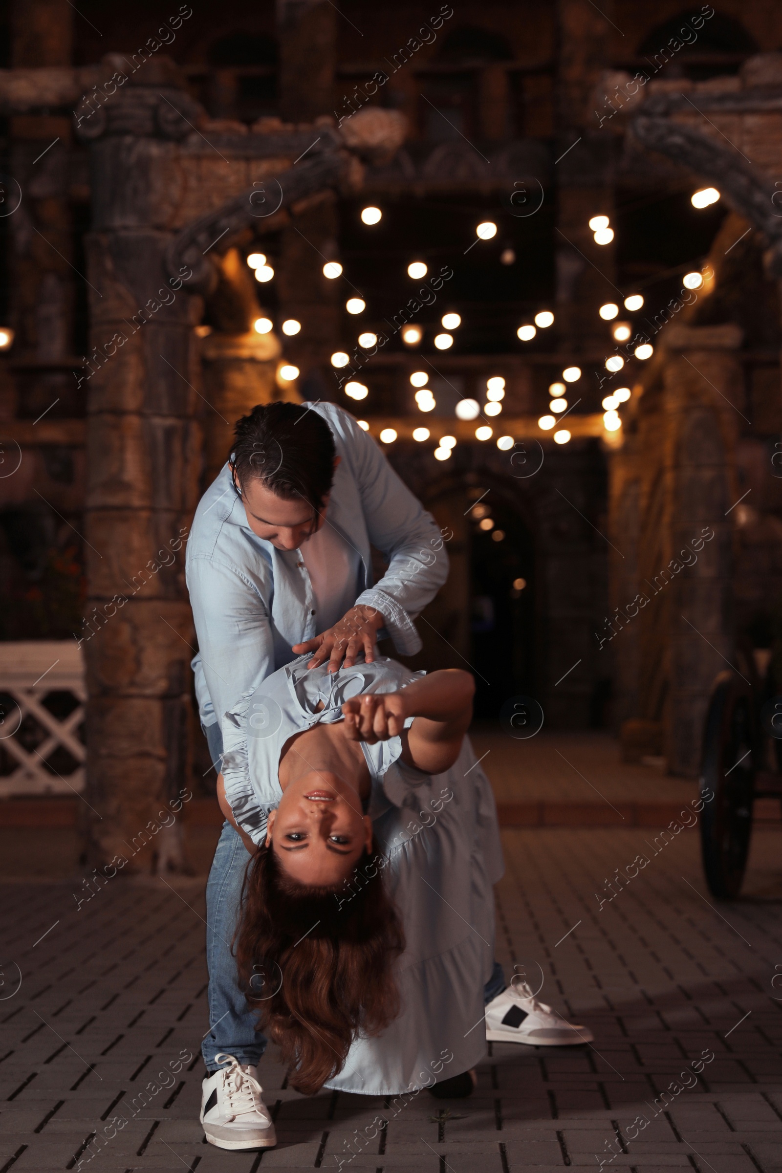 Photo of Beautiful young couple practicing dance moves in evening outdoors