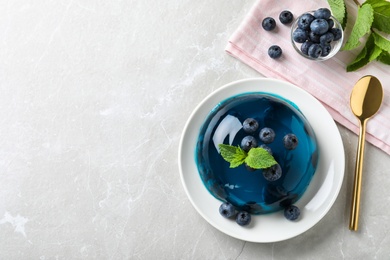 Photo of Delicious jelly with blueberries and mint on grey table, flat lay. Space for text