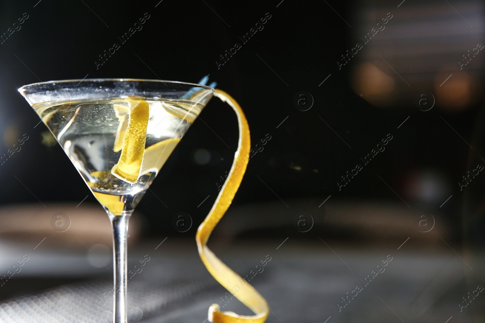 Photo of Glass of lemon drop martini cocktail in bar, closeup. Space for text