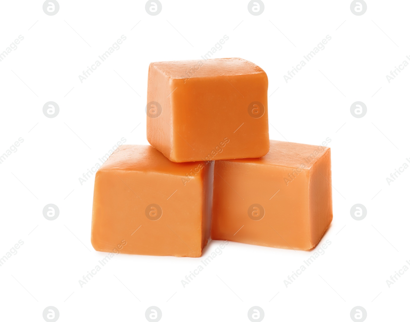 Photo of Three caramel cubes on white background. Confectionery