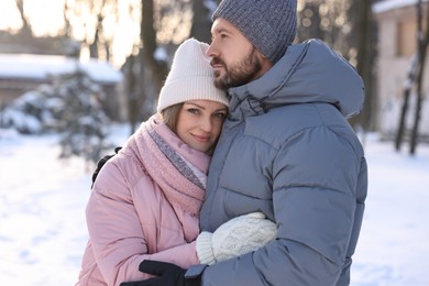 Photo of Family portrait of beautiful couple in snowy park