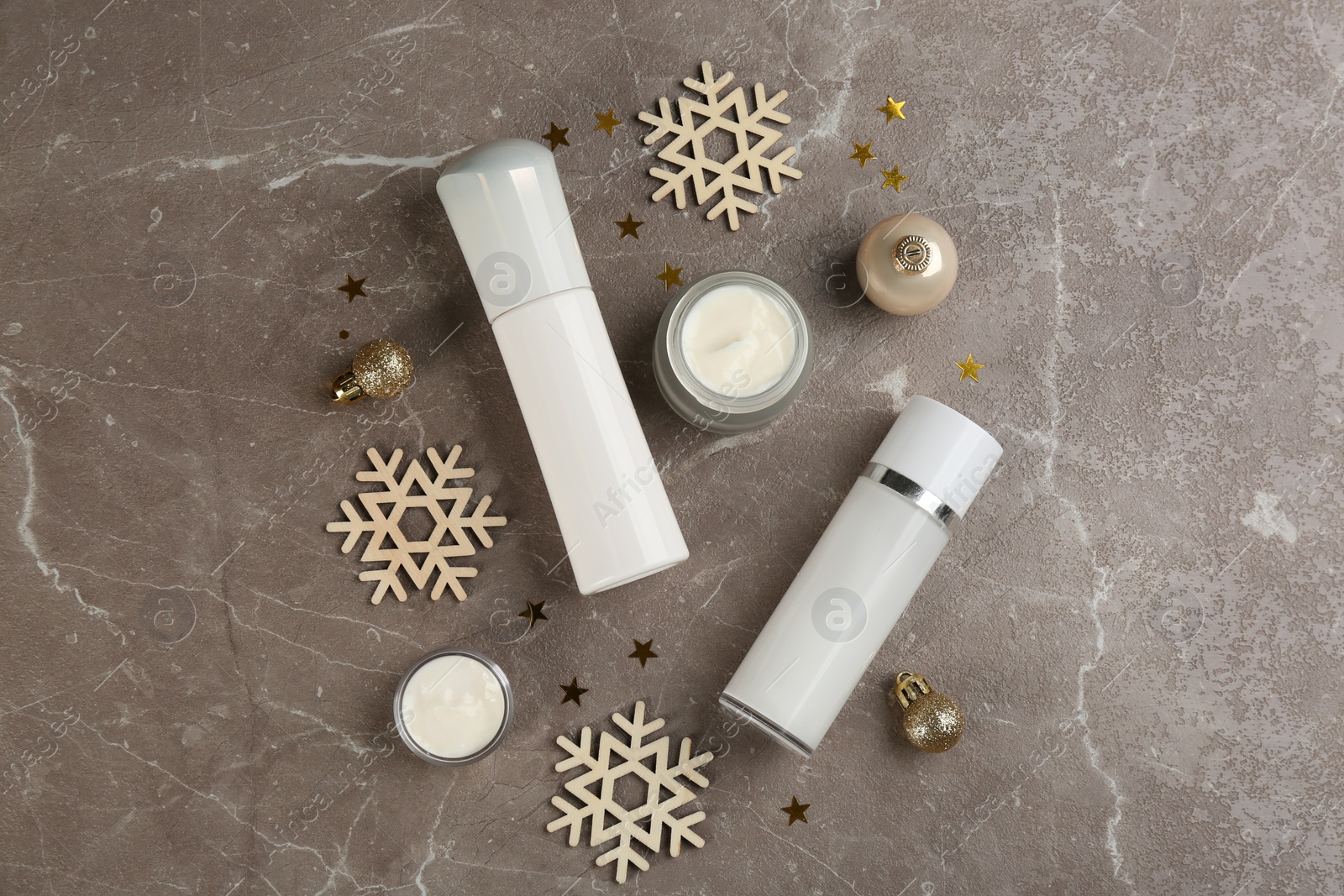 Photo of Flat lay composition with  different cosmetic products on grey table, flat lay. Winter care
