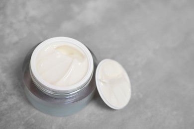 Photo of Body cream on grey table, closeup. Space for text