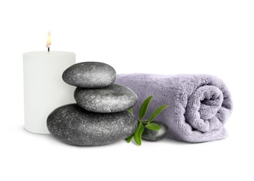 Image of Beautiful composition with burning candle, stacked stones and rolled towel on white background. Spa therapy