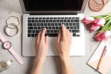 Woman working with laptop at table, top view