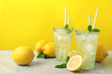 Photo of Natural freshly made lemonade on light grey marble table. Summer refreshing drink