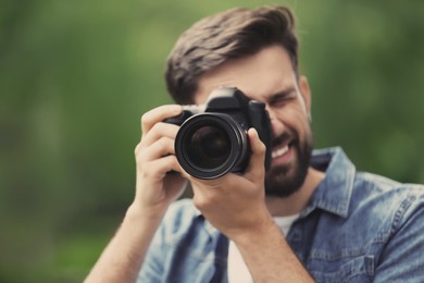 Image of Professional photographer with camera on blurred background