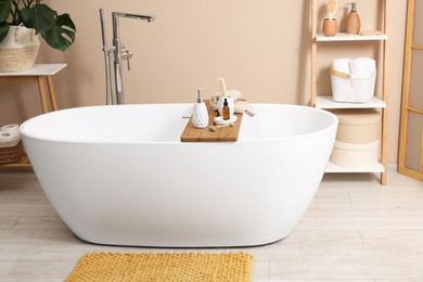 Photo of Different personal care products and accessories on bath tub in bathroom