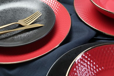 Stylish ceramic plates and cutlery on table, closeup