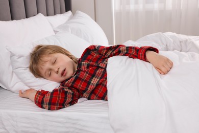 Photo of Little boy snoring while sleeping in bed at home