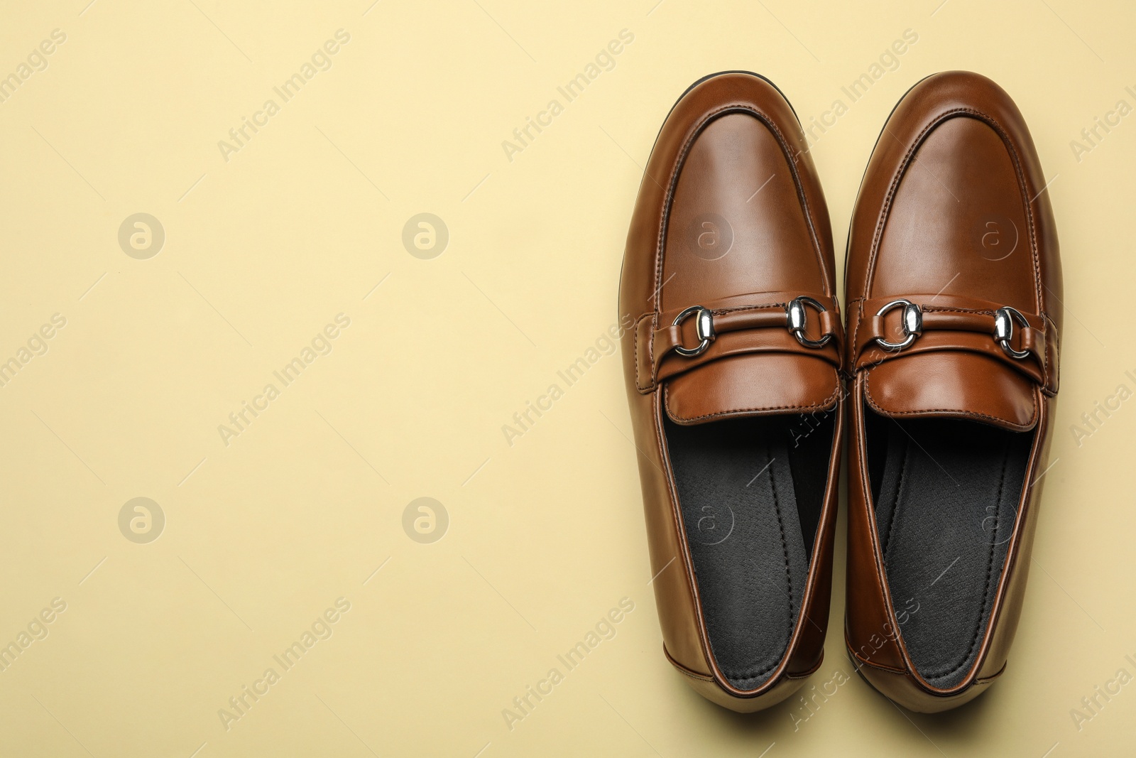 Photo of Pair of stylish male shoes on yellow background, top view. Space for text