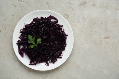 Photo of Tasty red cabbage sauerkraut and parsley on beige table, top view. Space for text