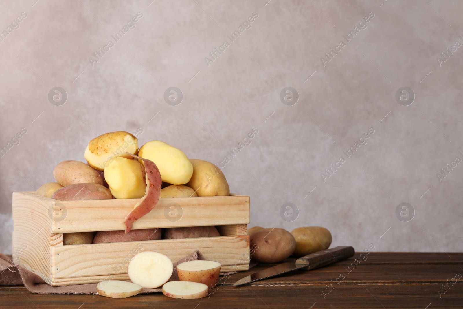 Photo of Fresh organic potatoes in wooden crate on table