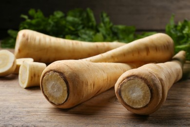 Photo of Fresh ripe parsnips on wooden table, closeup