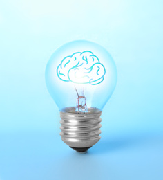 Image of Lamp bulb with human brain inside on blue background. Idea generation
