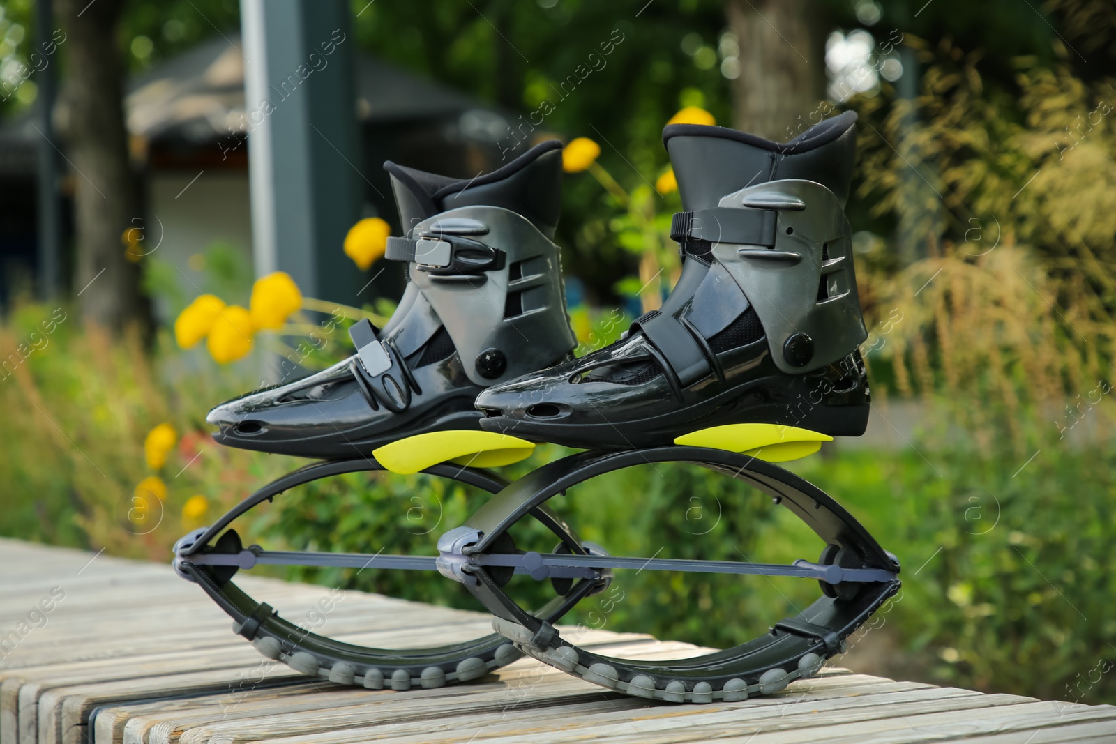 Photo of Stylish kangoo jumping boots on wooden bench outdoors