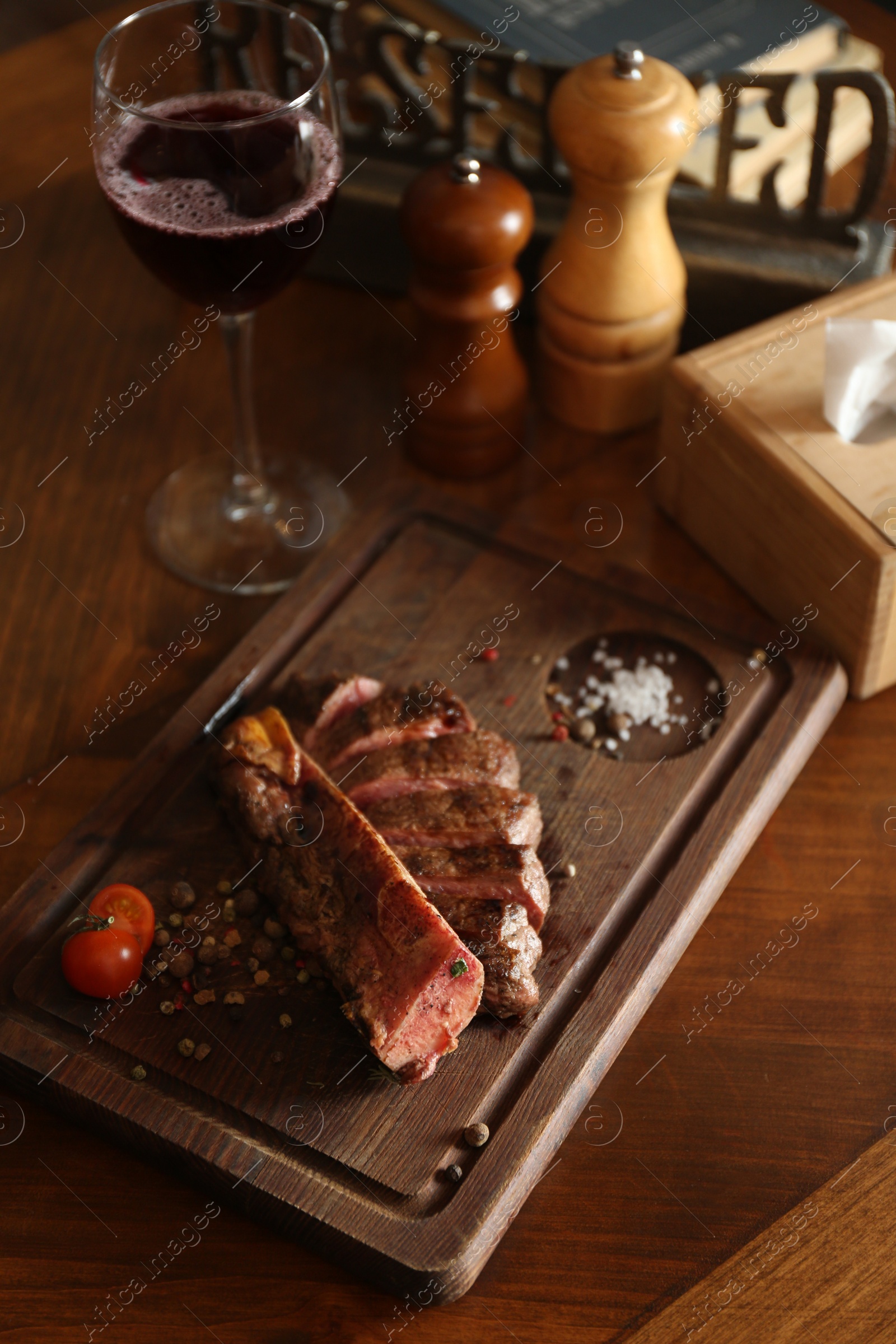 Photo of Tasty roasted meat served on wooden table in restaurant. Cooking food