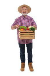 Harvesting season. Happy farmer holding wooden crate with vegetables on white background