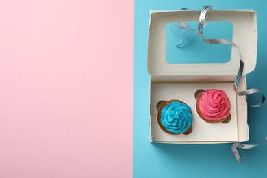 Photo of Box with different delicious cupcakes on color background, top view. Space for text