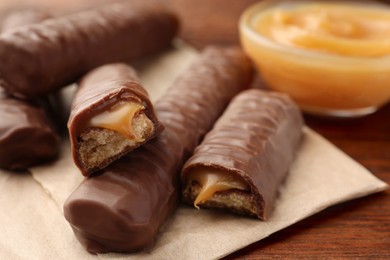 Sweet tasty chocolate bars with caramel on wooden table