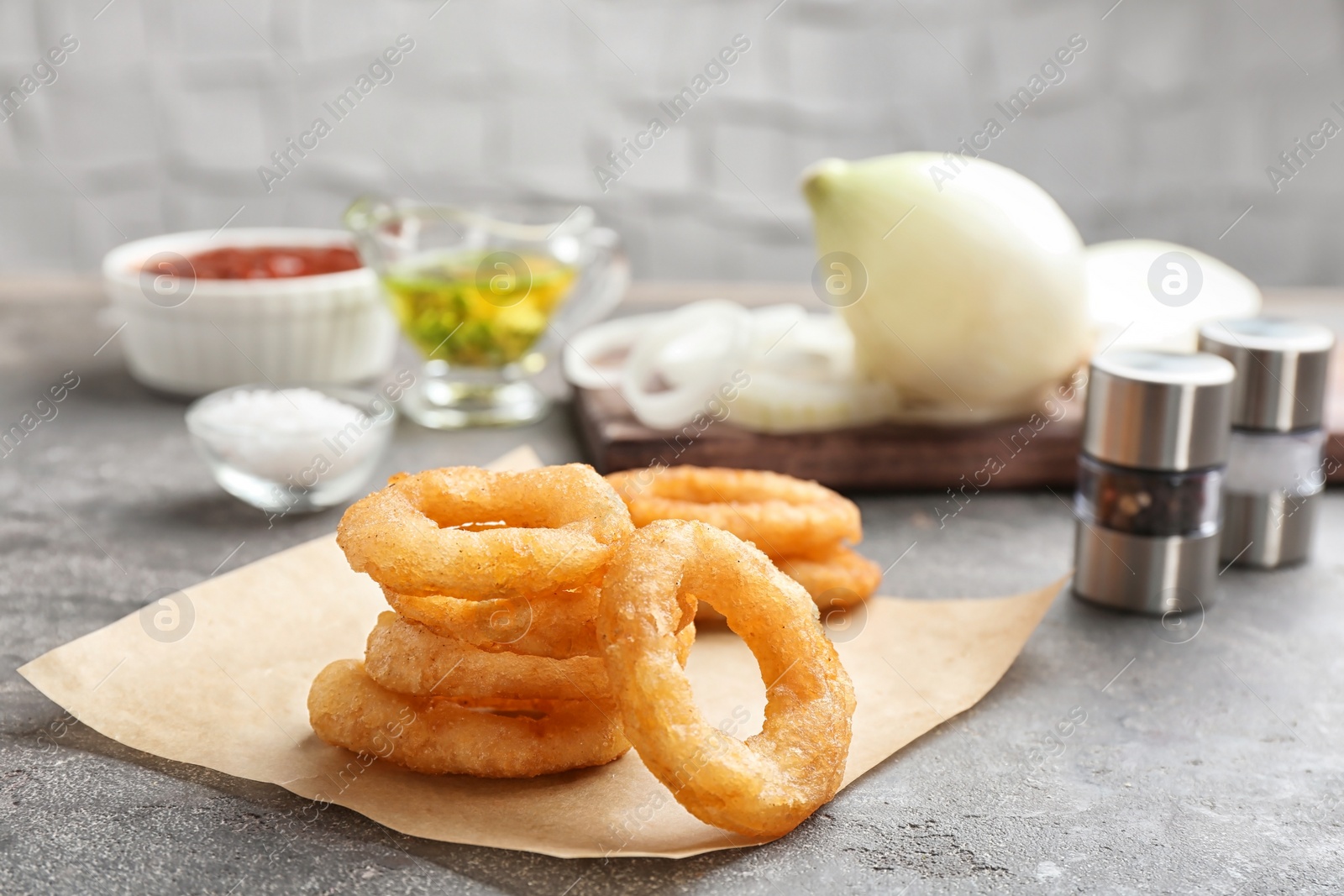 Photo of Stack of fried onion rings on table, closeup