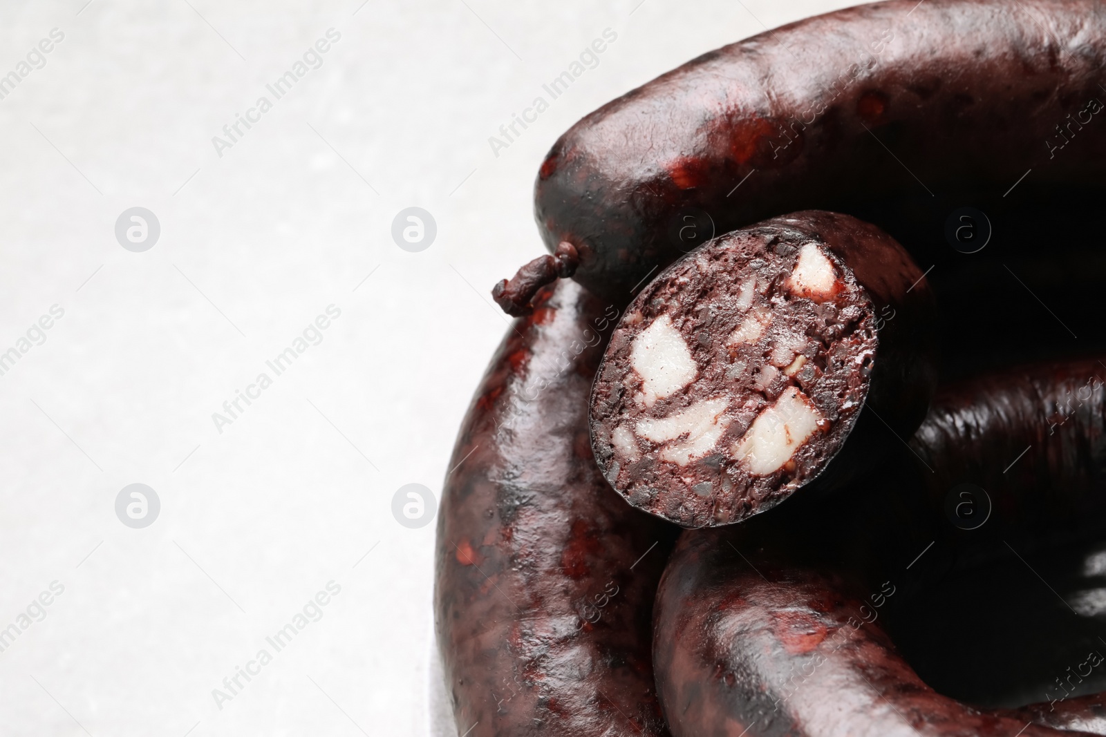 Photo of Tasty blood sausages on light grey table, above view. Space for text