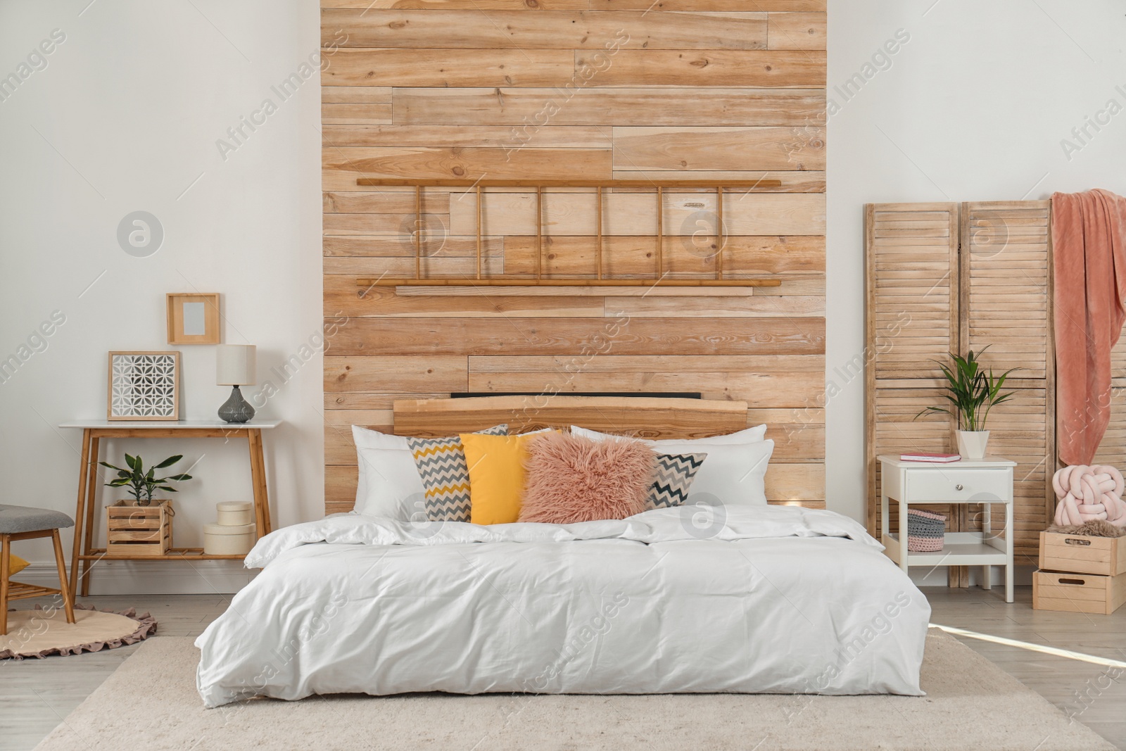 Photo of Stylish room interior with comfortable bed near wooden wall