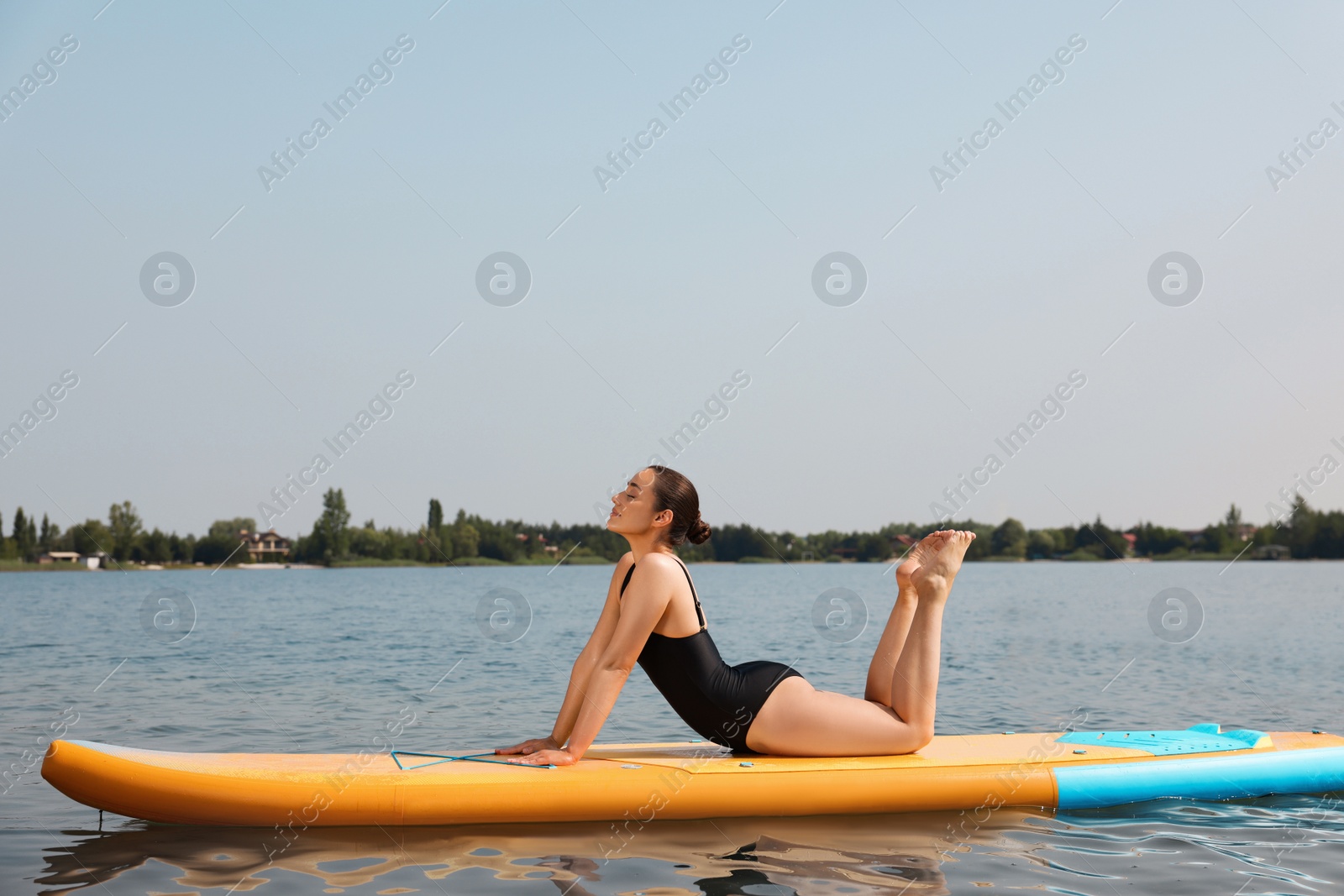 Photo of Woman practicing yoga on SUP board on river