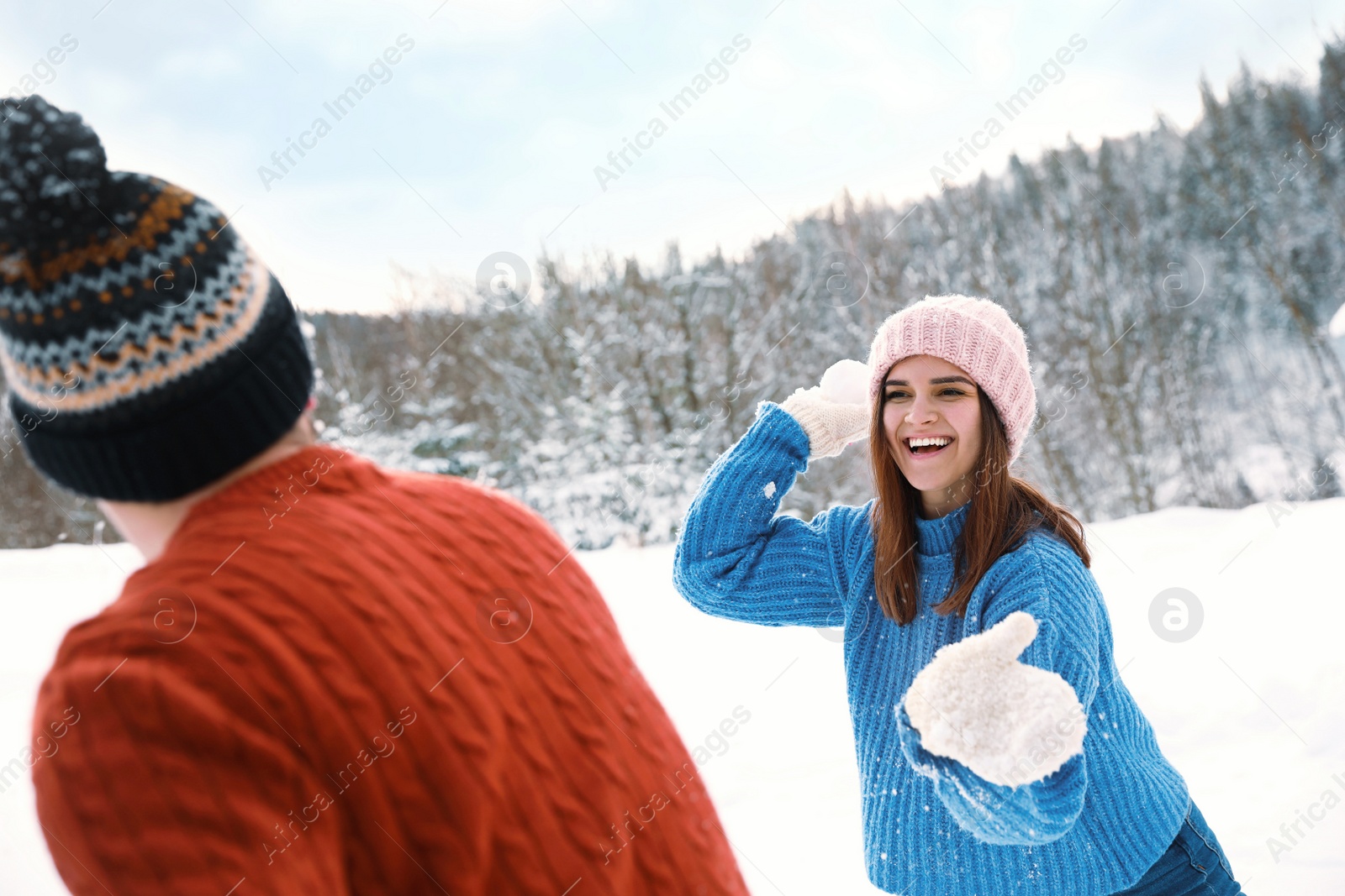 Photo of Happy couple playing snowballs outdoors. Winter vacation