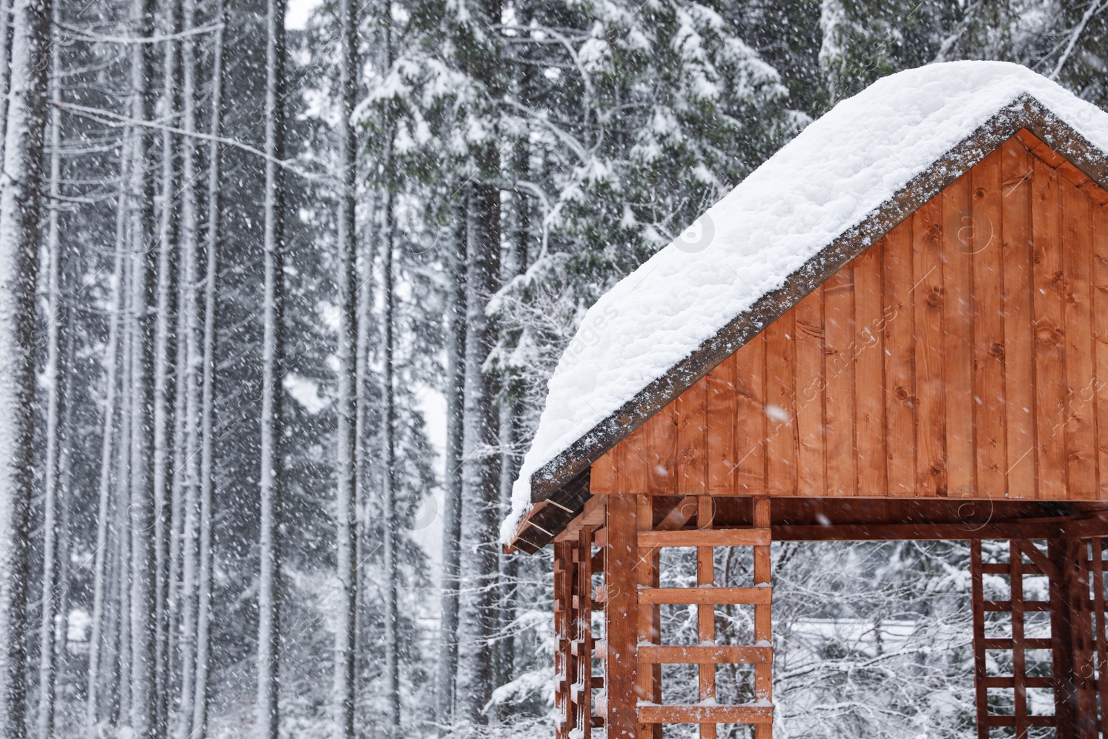 Photo of Modern wooden gazebo on snowy day. Winter vacation