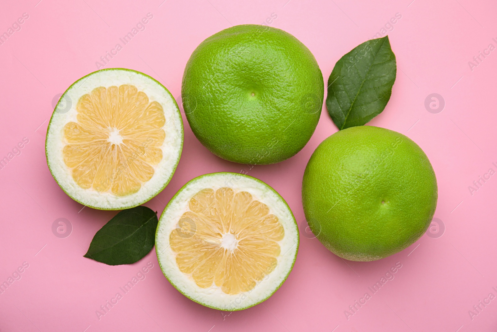 Photo of Tasty whole and cut sweeties on pink background, flat lay