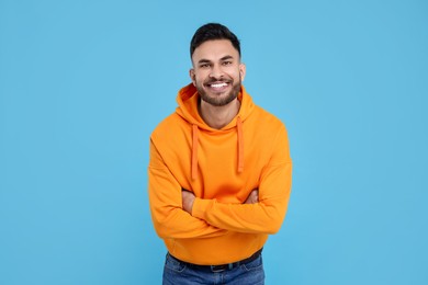 Photo of Handsome young man laughing on light blue background