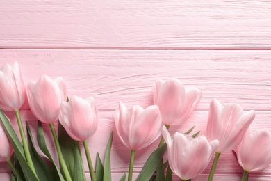 Beautiful tulips for Mother's Day on wooden background, top view