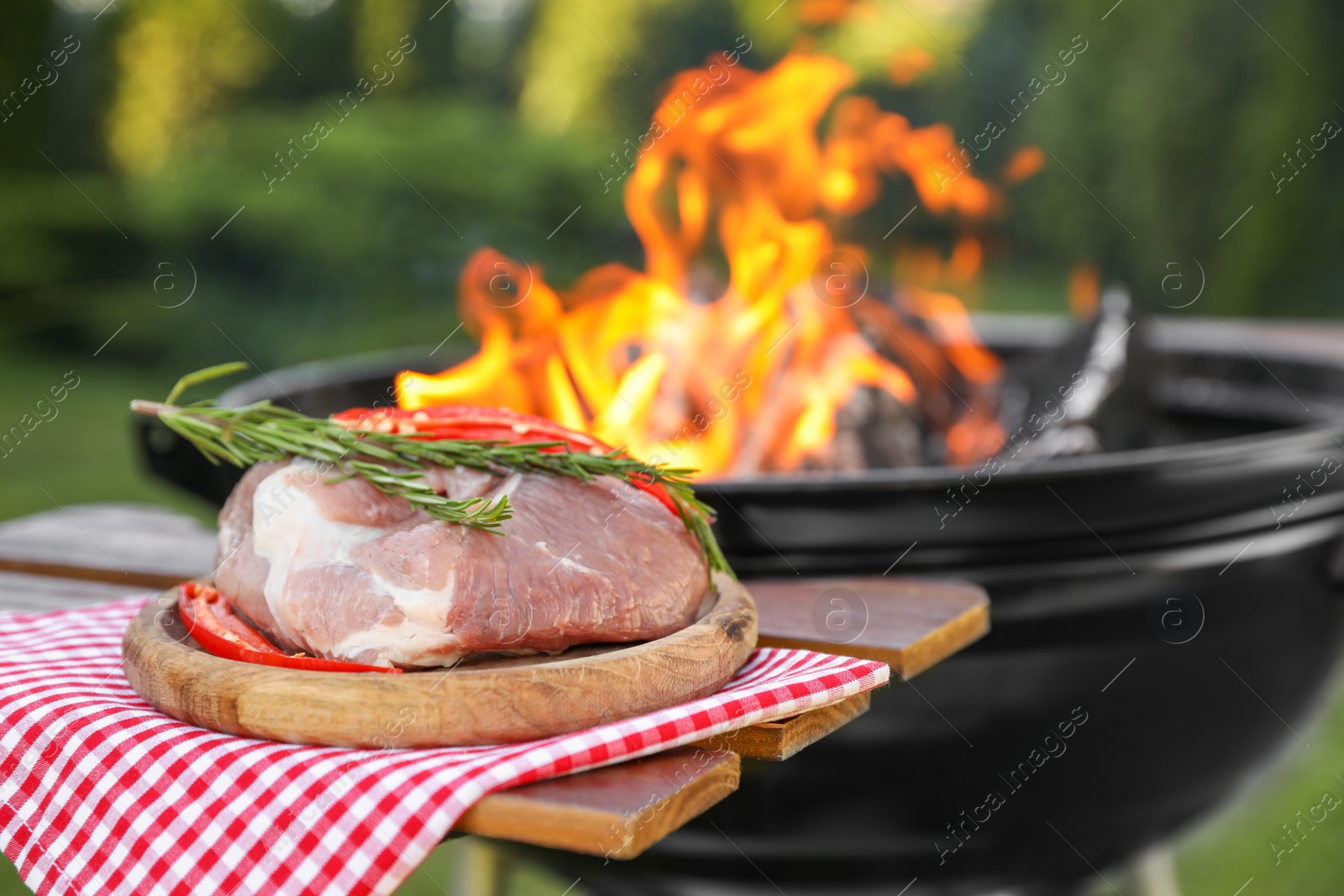 Photo of Raw meat on table near barbecue grill outdoors