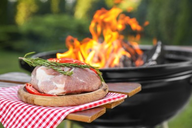 Photo of Raw meat on table near barbecue grill outdoors