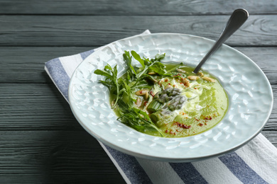 Delicious asparagus soup served on grey wooden table