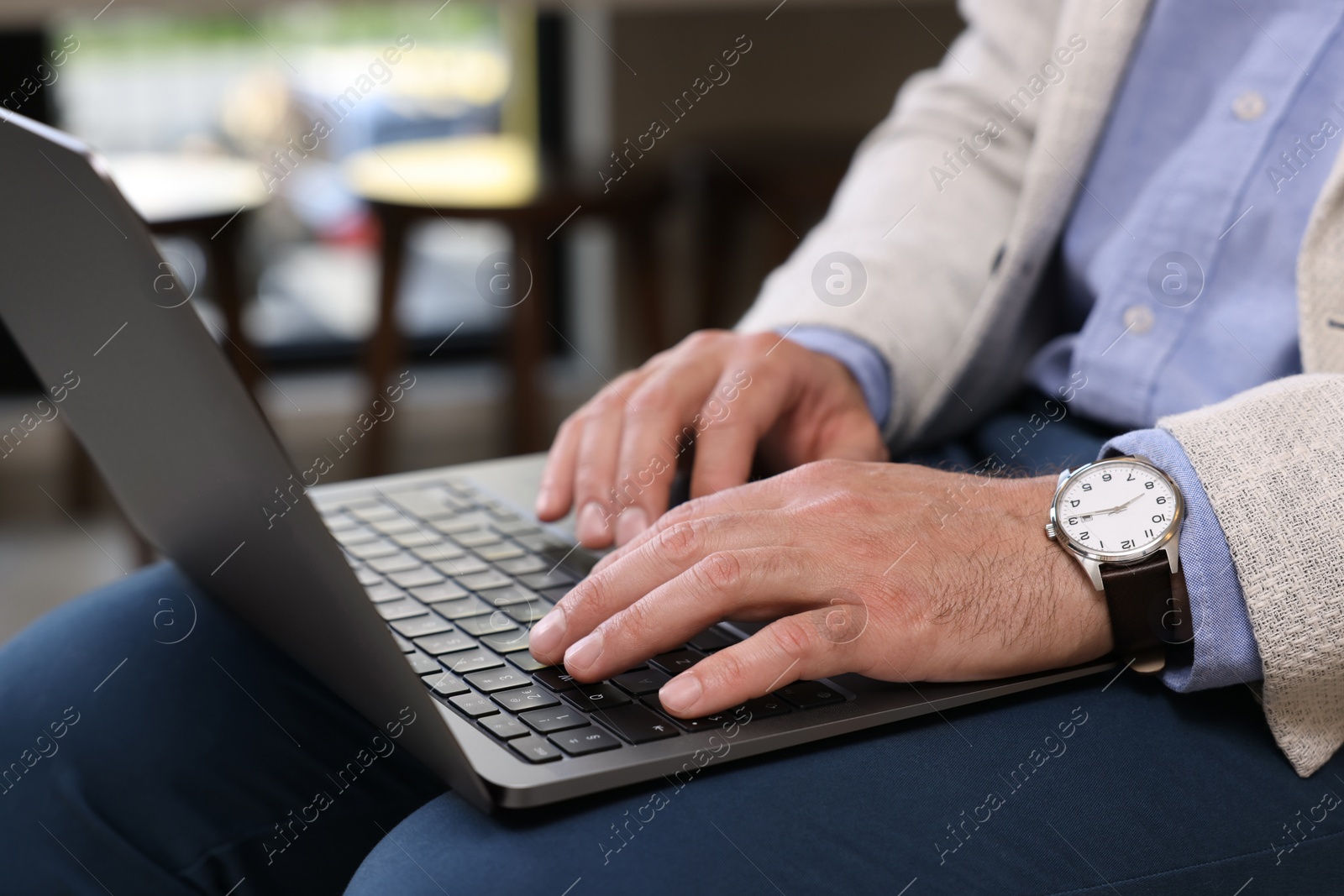 Photo of Man using modern laptop in cafe, closeup