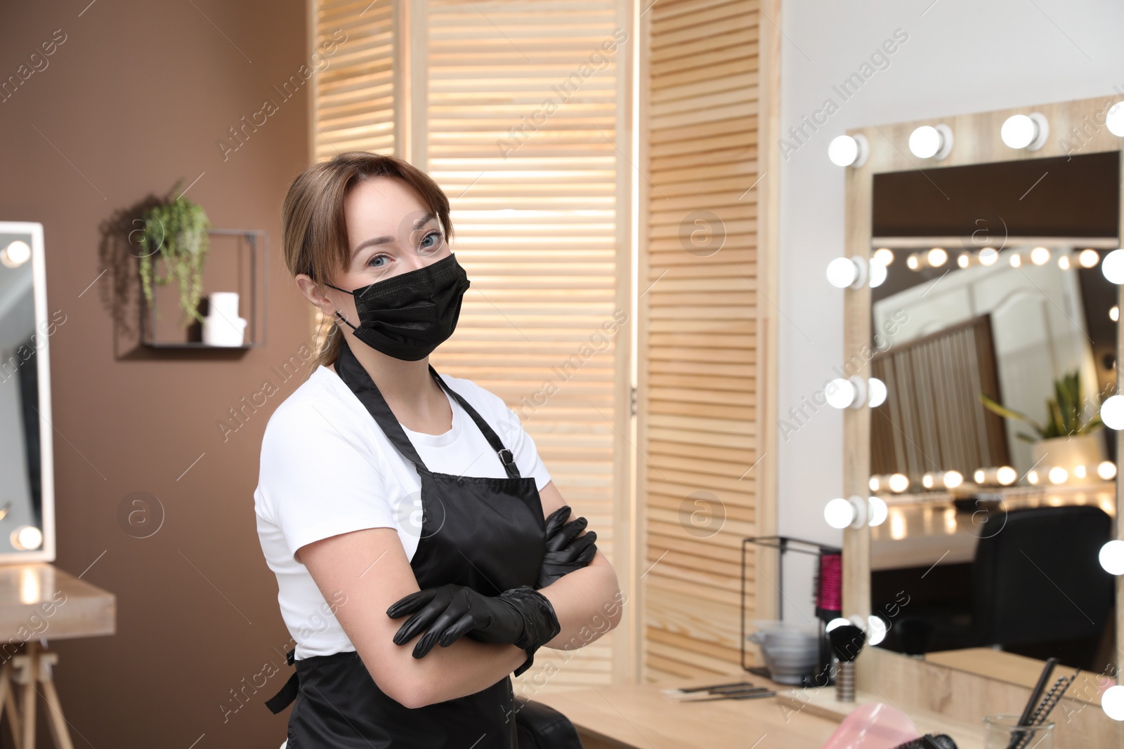 Photo of Portrait of stylist with protective mask in salon, space for text. Beauty services during Coronavirus quarantine