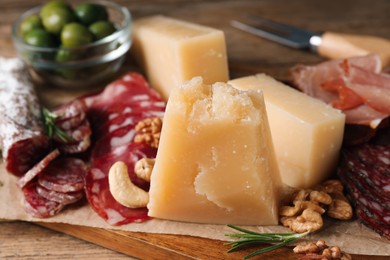 Snack platter with parmesan cheese on wooden table, closeup