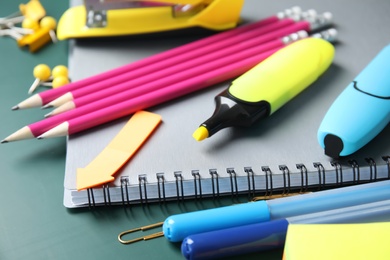 Photo of Different colorful stationery on chalkboard surface. Back to school