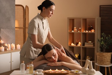 Photo of Spa therapy. Beautiful young woman lying on table during massage in salon