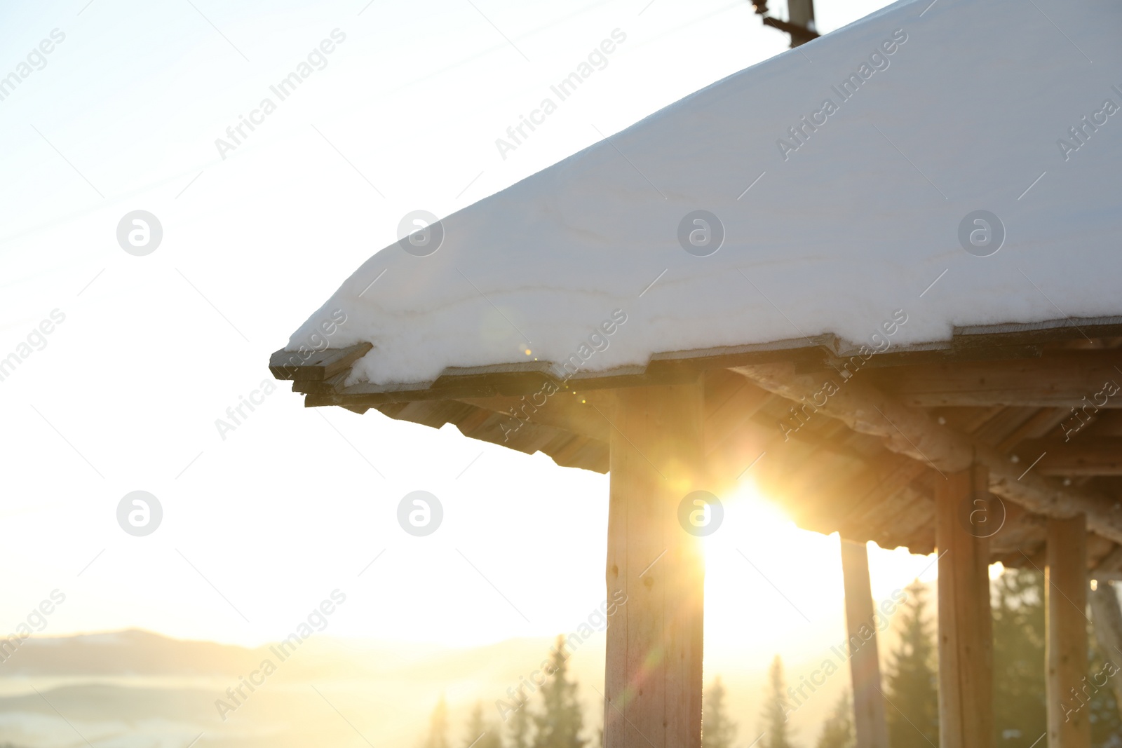 Photo of Wooden gazebo near snowy coniferous forest, closeup. Winter vacation