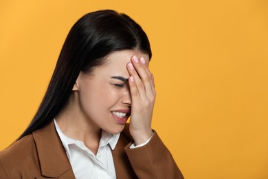 Photo of Woman suffering from migraine on yellow background, space for text