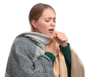 Young woman wrapped in warm blanket suffering from cold on white background