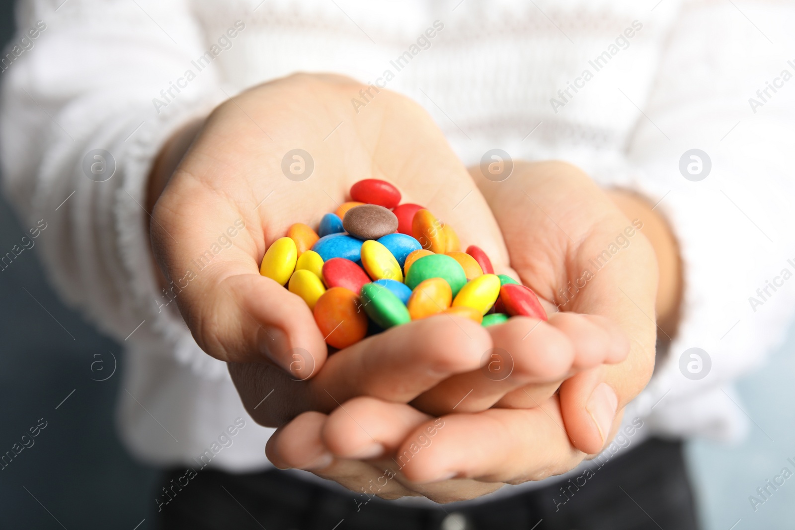 Photo of Woman holding many tasty glazed candies, closeup