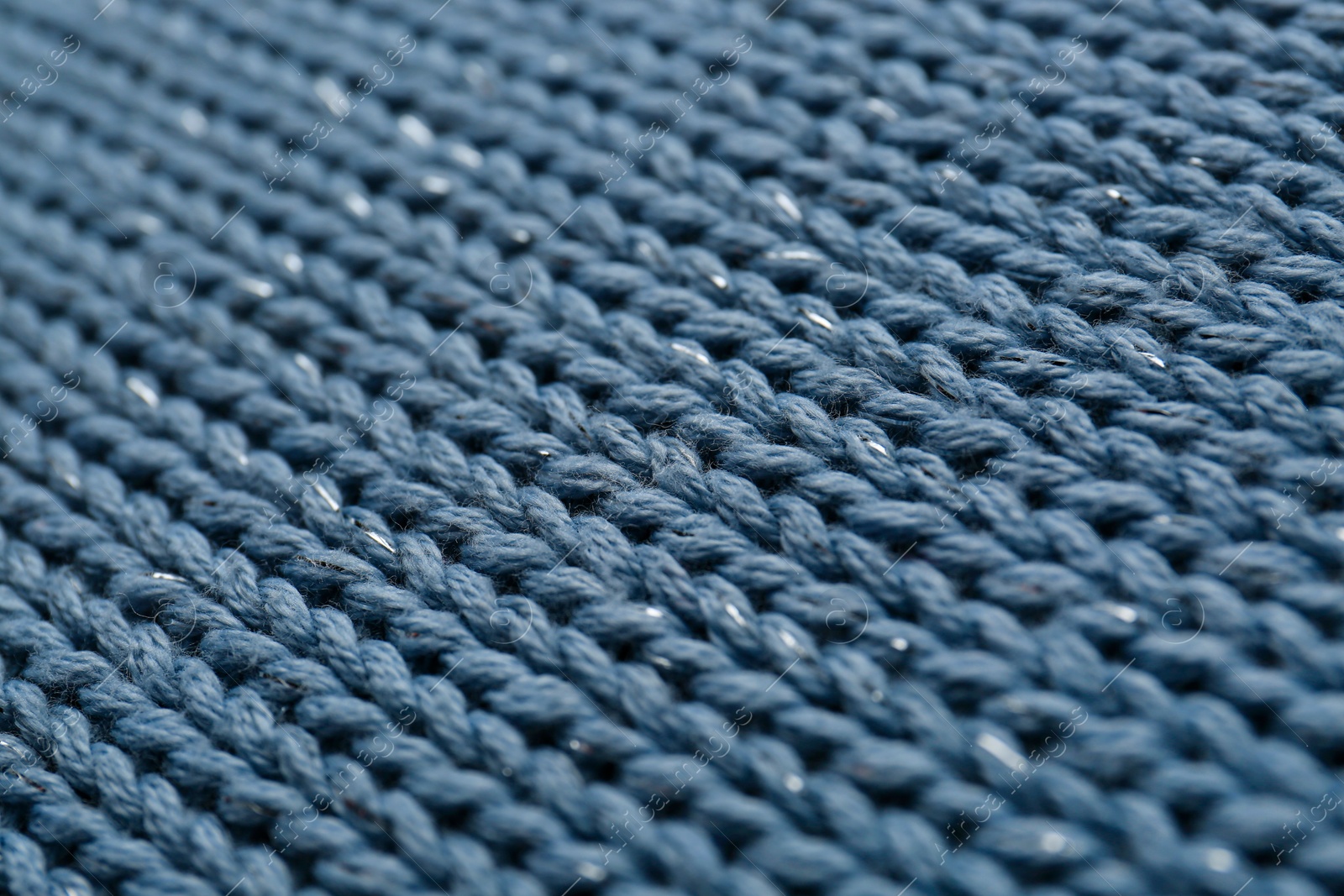 Photo of Beautiful pale blue knitted fabric as background, closeup