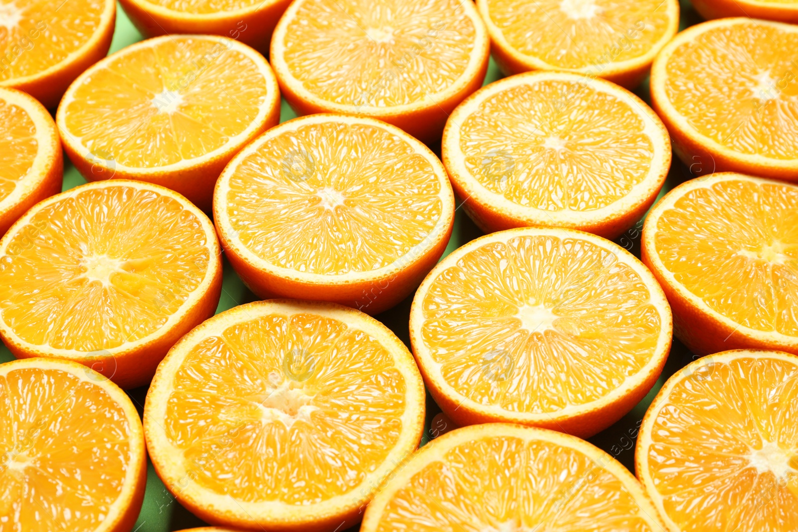 Photo of Halves of ripe oranges as background, closeup